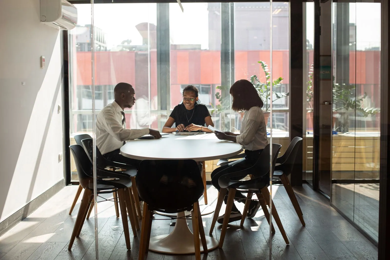 Colleagues meeting around a round table in a contemporary office