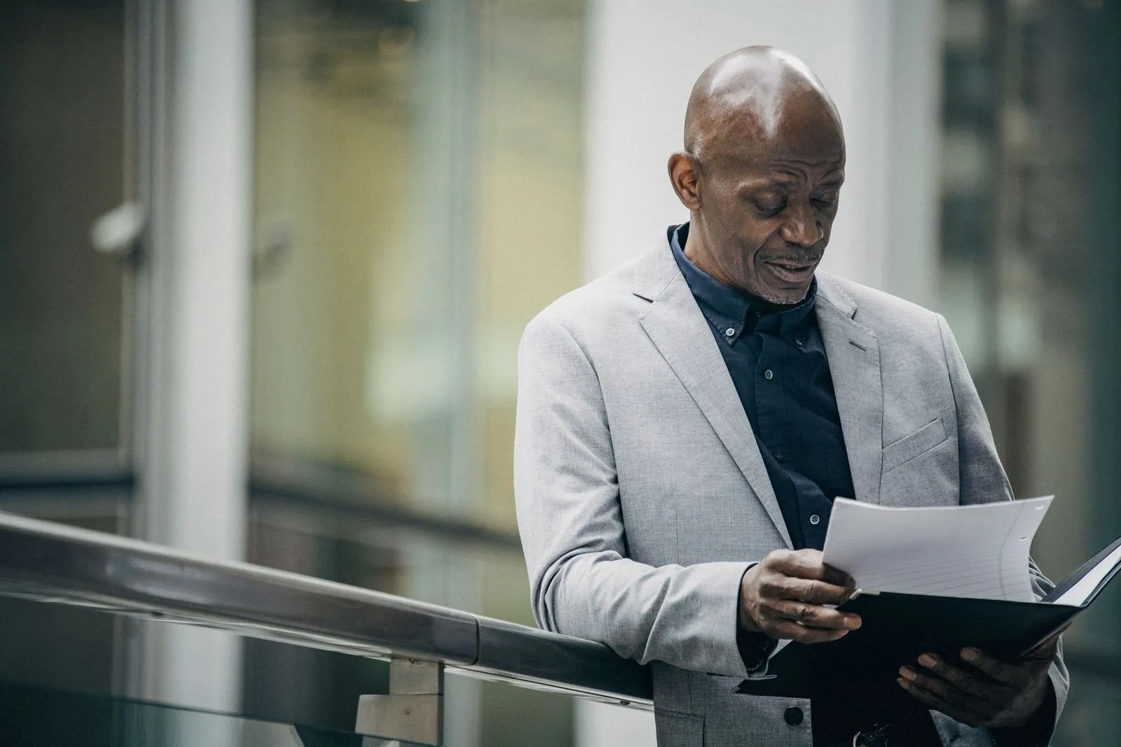 Senior professional reviewing documents in a modern office building
